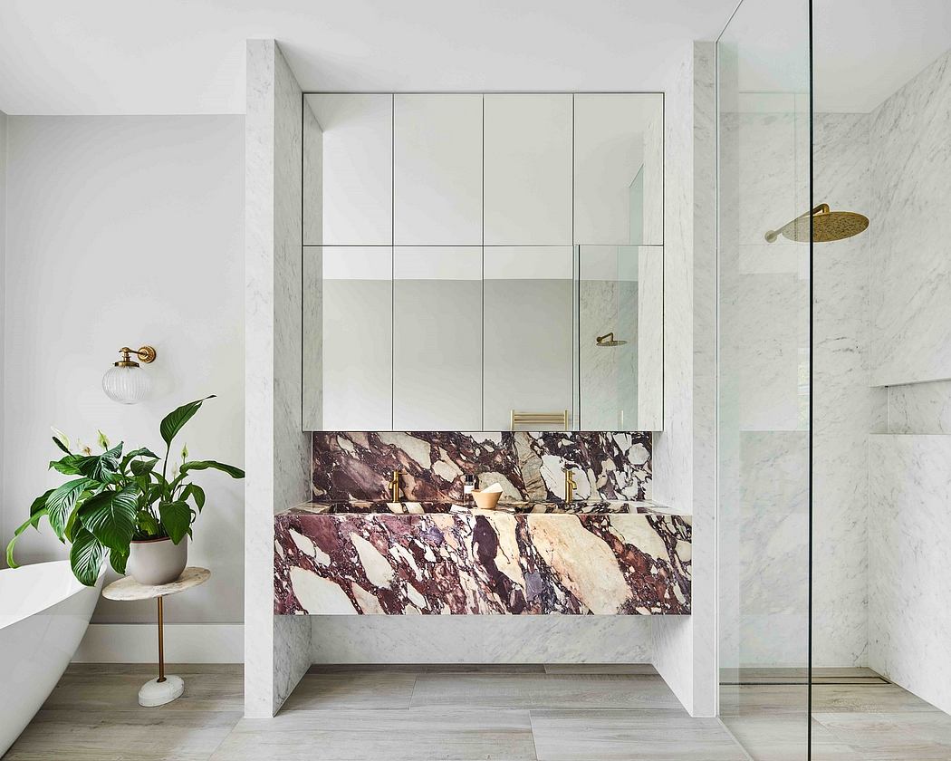 Sleek, modern bathroom with dramatic marbled vanity and glass shower enclosure.