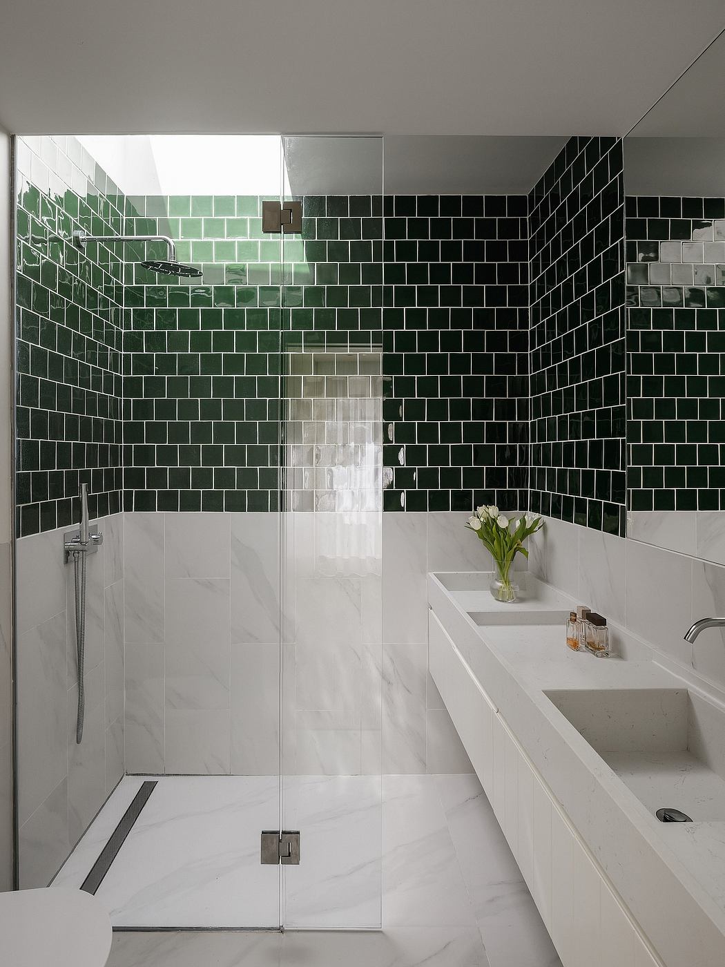 A modern bathroom with a seamless glass shower and a striking monochrome tile wall.