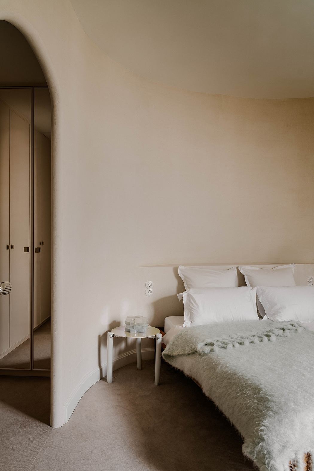 Cozy bedroom with neutral color palette, plush bedding, and minimal decor.