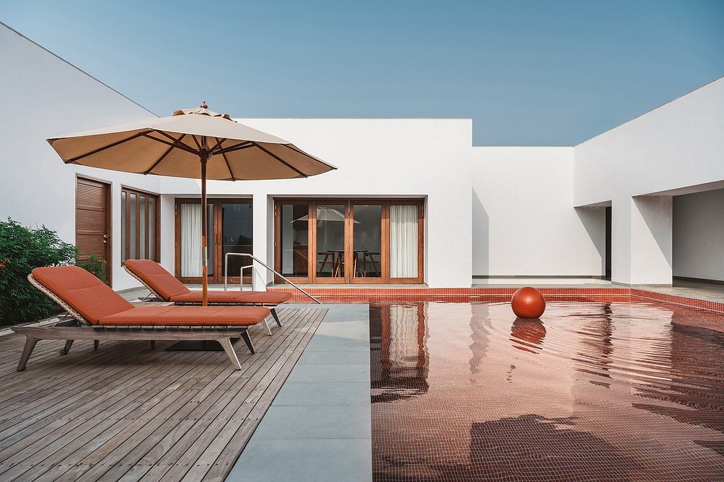 Minimalist contemporary home with pool, lounge chairs, and umbrella on wooden deck.