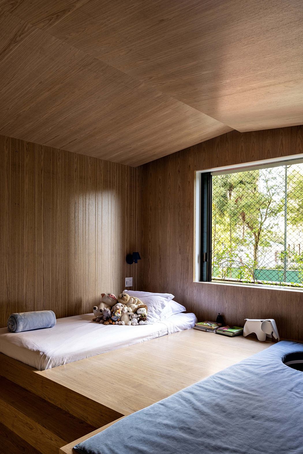 A cozy bedroom with wooden walls, large windows, and comfortable bedding.