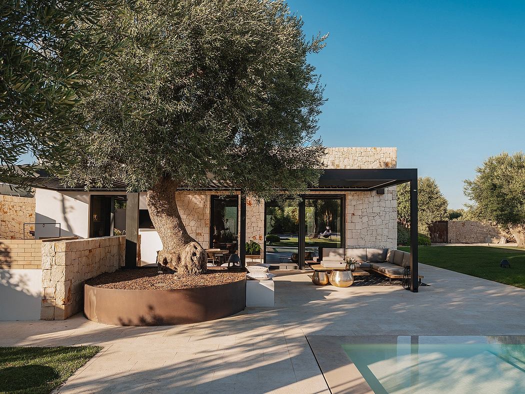 An elegant modern home with a pool, surrounded by lush greenery and stone walls.