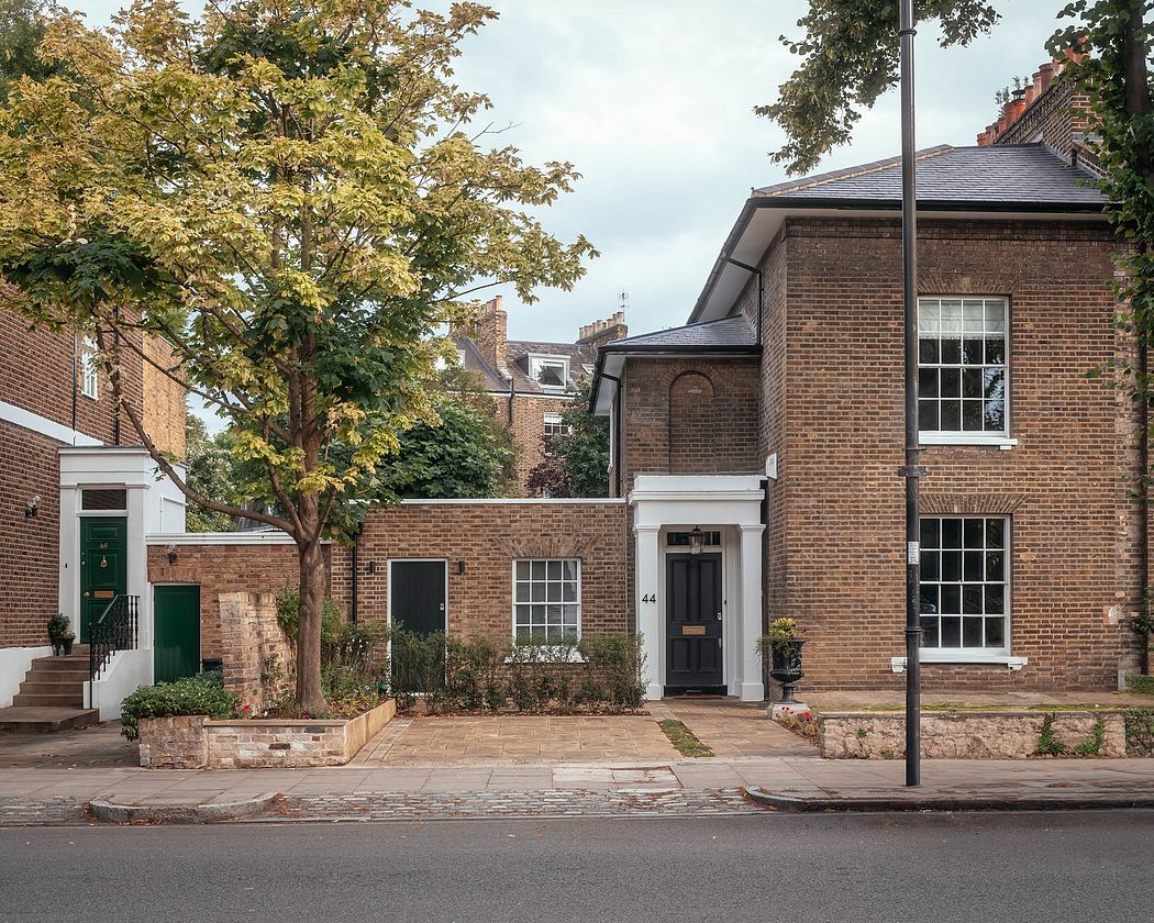 Elegant brick townhouse with arched entryway, symmetrical windows, and landscaped garden.