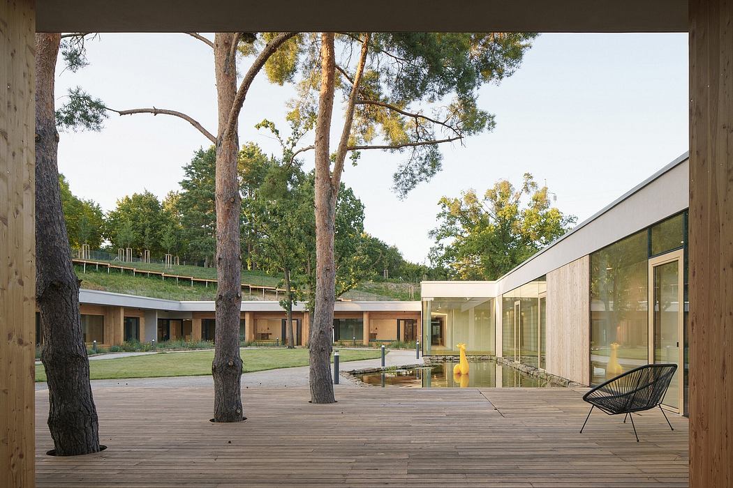 Sleek modern structure surrounded by lush greenery, with a tranquil pond and seating area.