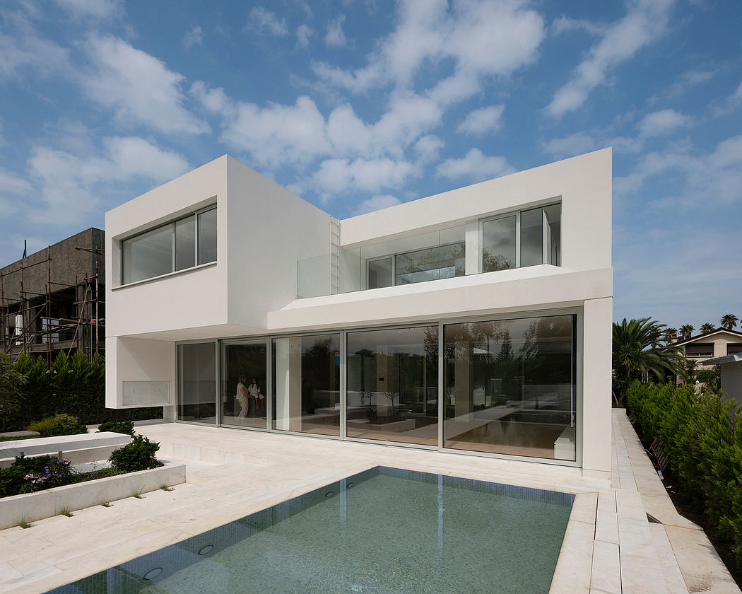 Sleek, modern architecture with expansive glass walls and a swimming pool.