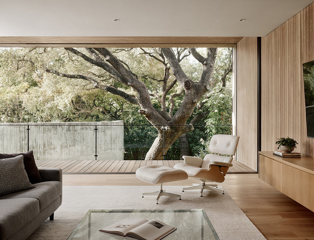 Expansive indoor-outdoor living space with large windows, wooden decor, and modern furniture.