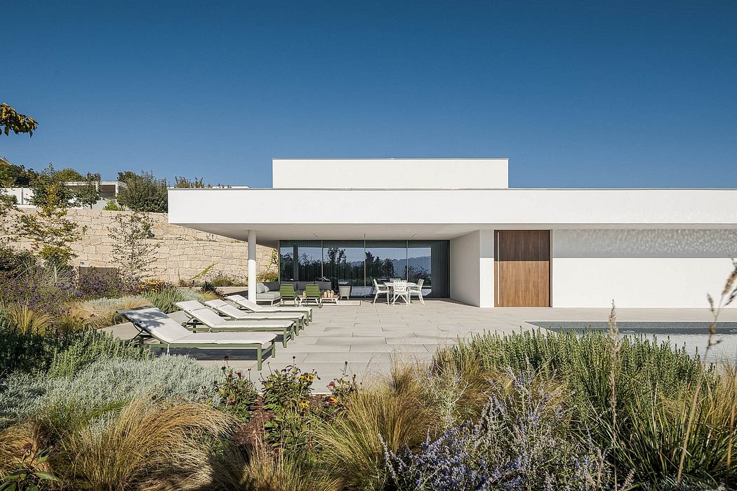 Minimalist modern architecture with clean lines, expansive patio, and lush landscaping.