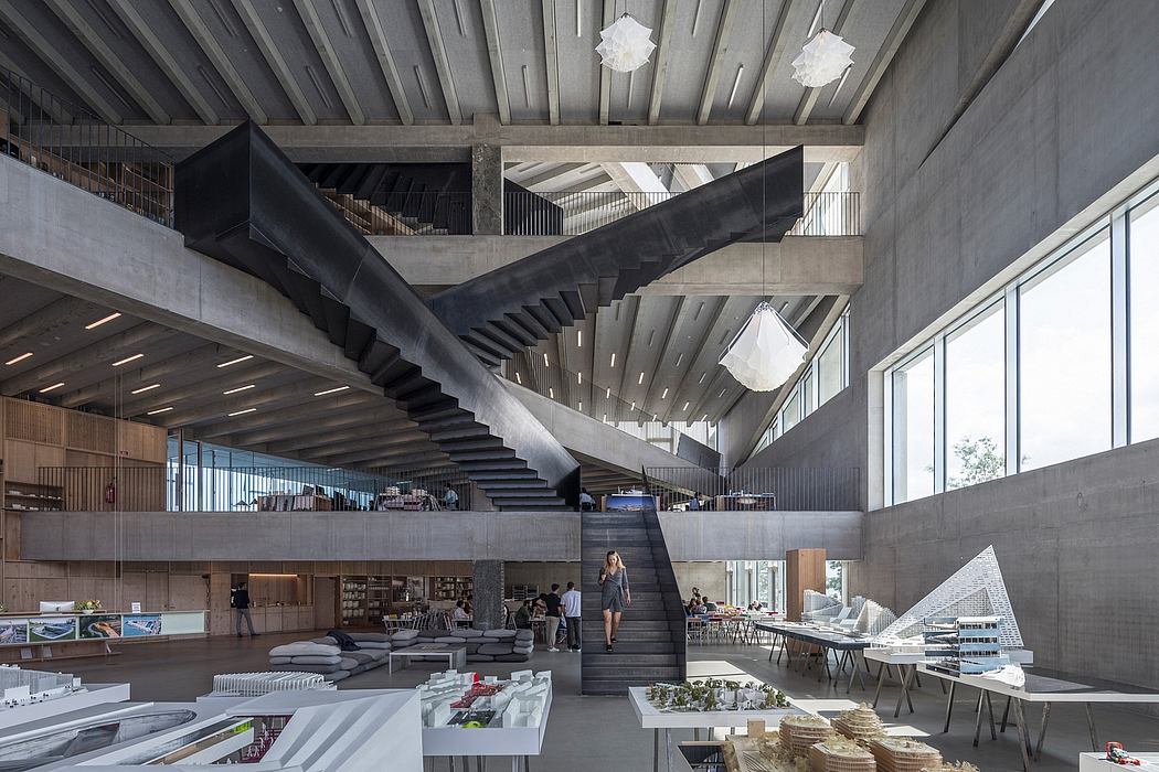 Dramatic concrete staircase and lighting fixtures in an expansive, modern interior space.