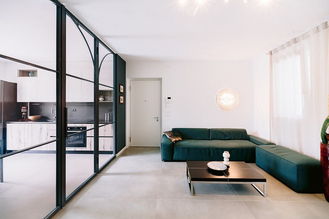 Sleek, modern interior with open-concept kitchen, green sectional sofa, and minimalist decor.