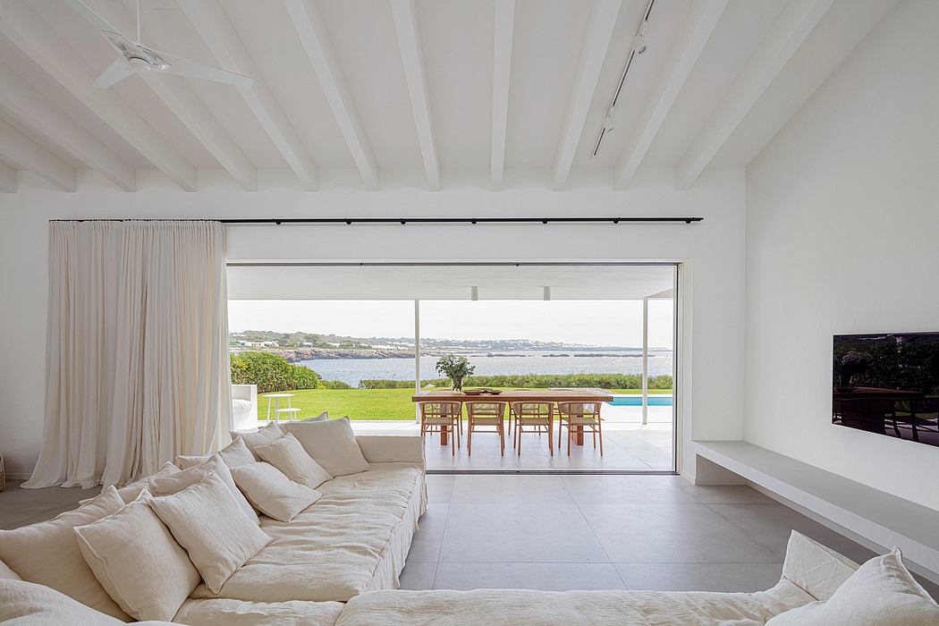 Bright, airy living room with large sliding glass doors leading to an outdoor pool area and scenic view.