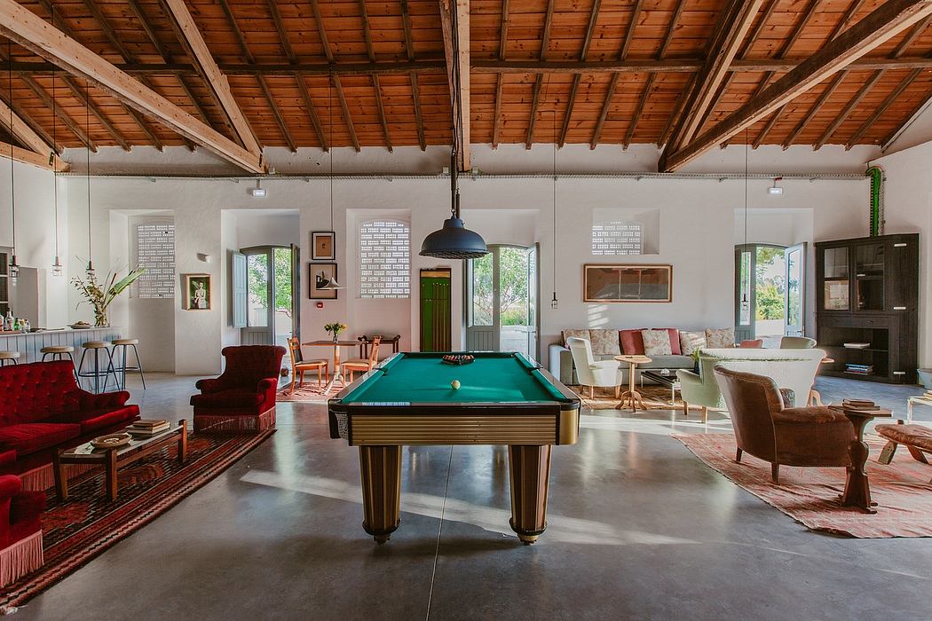 Spacious rustic-styled interior with wooden beams, cozy seating, and a pool table.