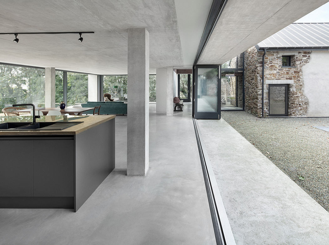 Spacious modern kitchen with expansive windows, concrete floors, and minimalist style.