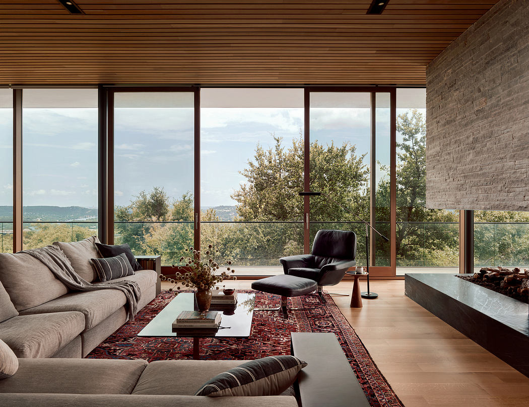 Spacious living room with floor-to-ceiling windows, cozy furniture, and striking rug.