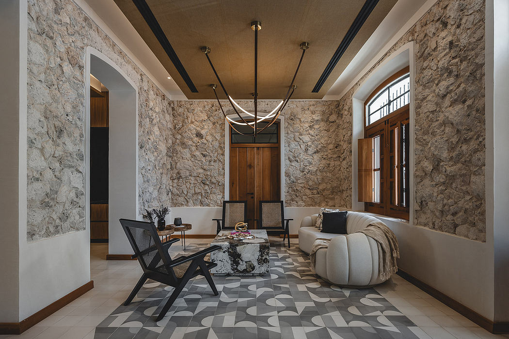 A cozy stone-walled living space with wooden accents, a contemporary chandelier, and patterned flooring.