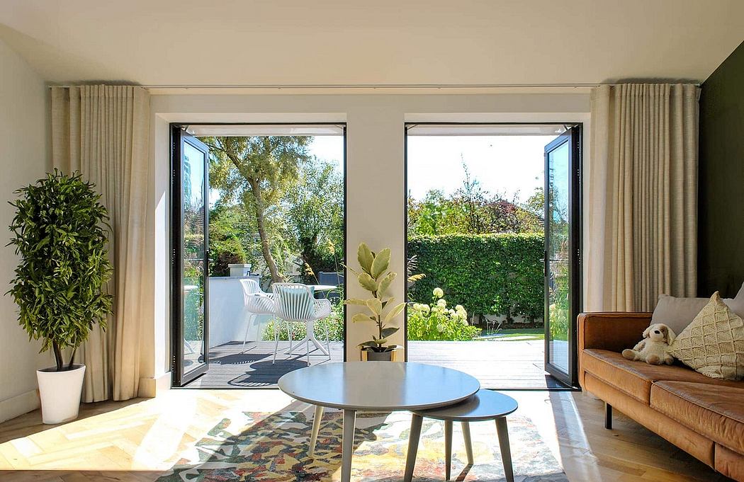 Bright and airy room with large windows overlooking a lush garden, modern furniture and decor.