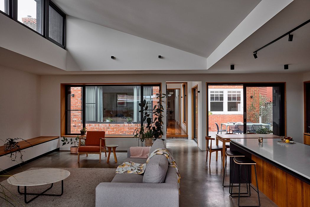 Spacious, modern open-plan living area with exposed brick walls and wooden furnishings.