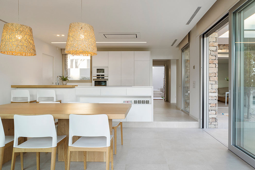 Open concept kitchen and dining area with white cabinets, wooden accents, and pendant lighting.