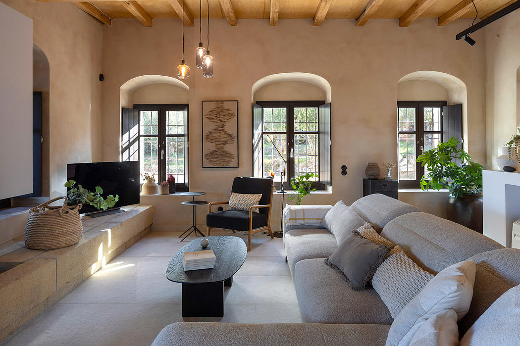 A cozy living room with arched windows, exposed beams, and a mix of modern and rustic decor.