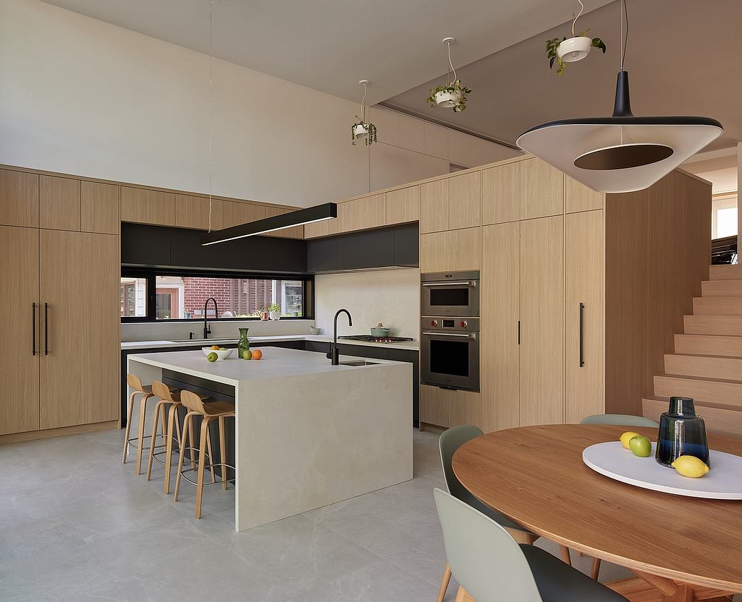 Modern open-concept kitchen with minimalist cabinetry, sleek island, and hanging light fixtures.
