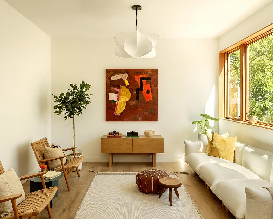 Warm, modern living room with abstract artwork, wood furniture, and large windows.