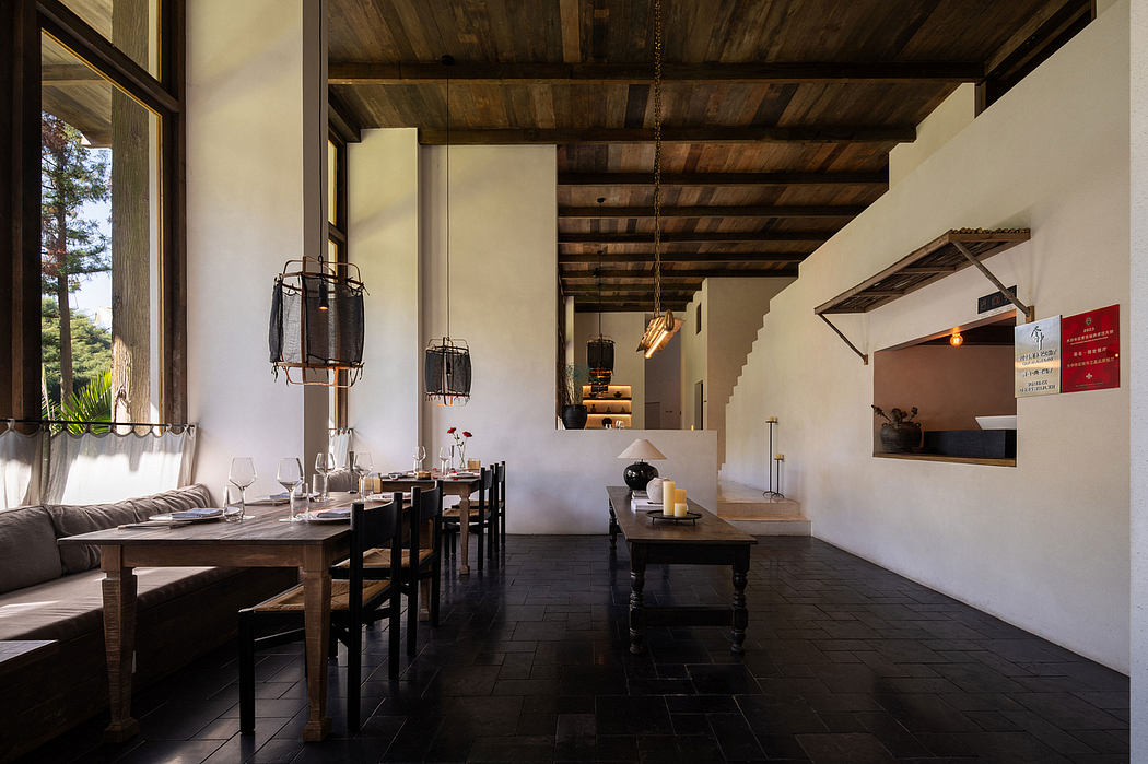 Rustic dining space with exposed wooden beams, pendant lamps, and wooden tables and chairs.