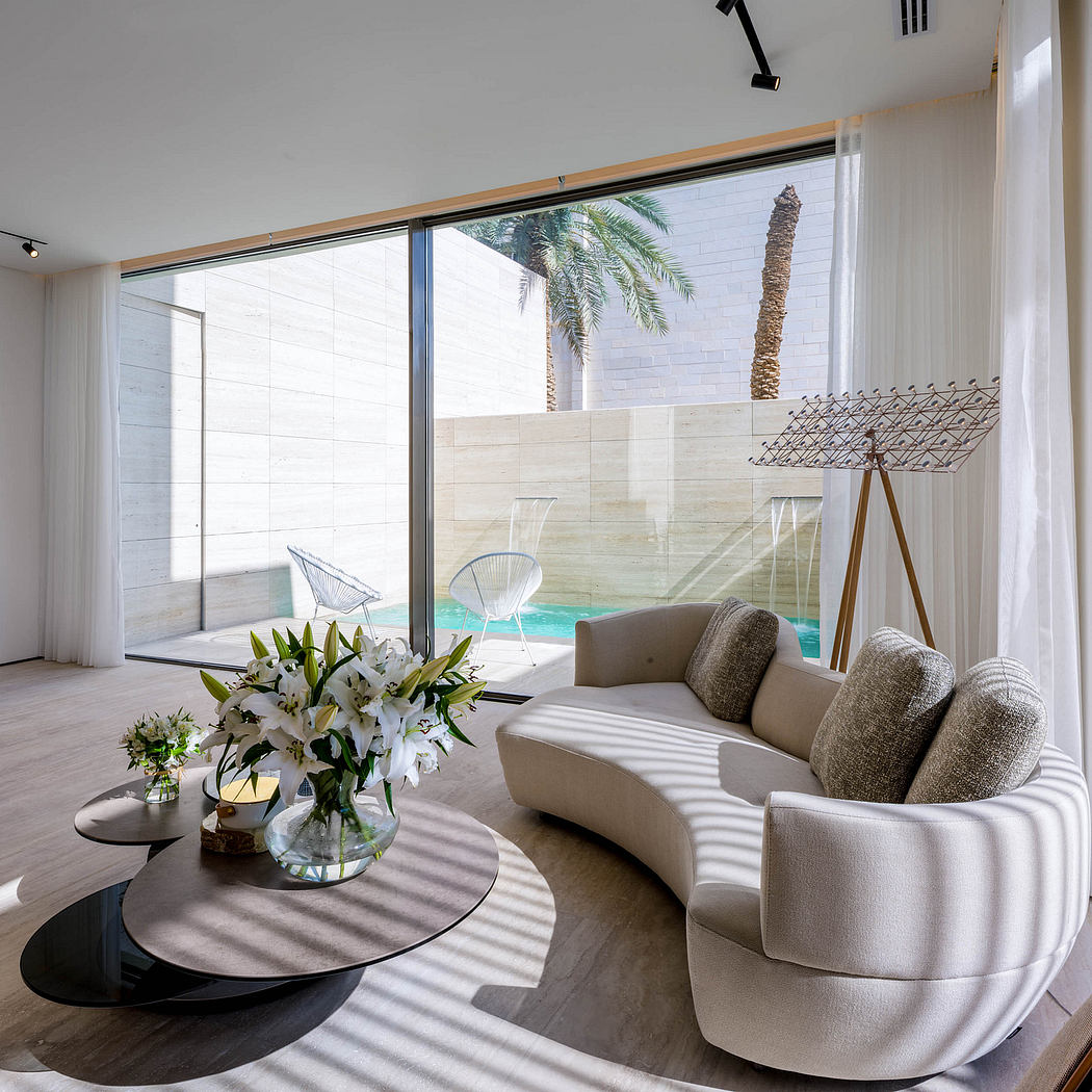 Luxurious modern living room with large windows, plush seating, and a stunning outdoor view.