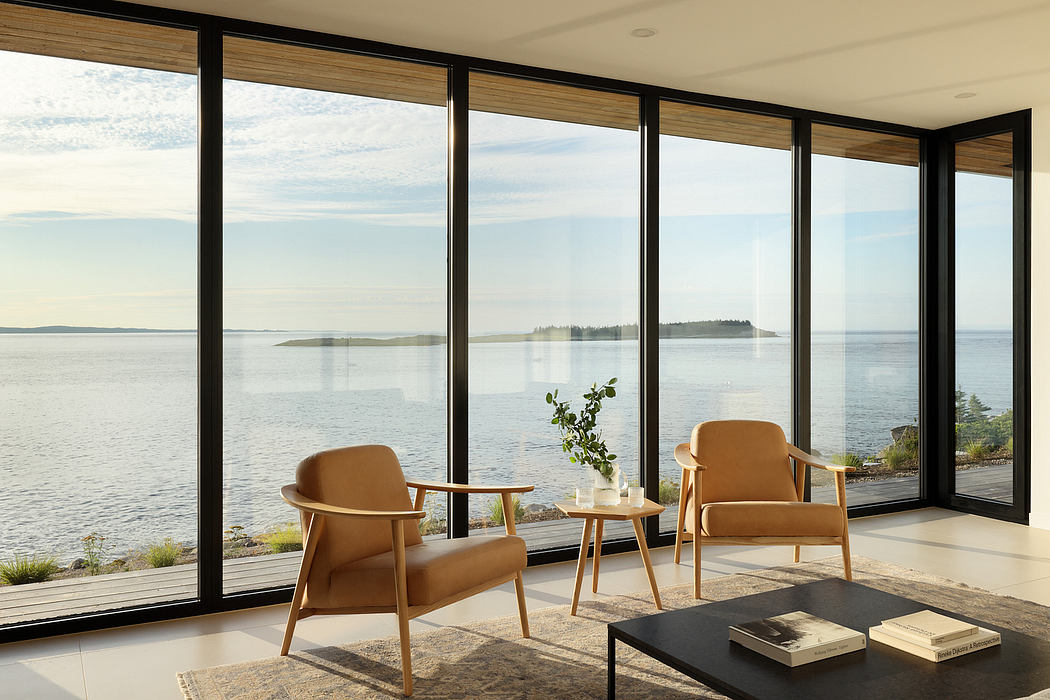 Modern, open-plan living space with floor-to-ceiling windows showcasing scenic waterfront view.