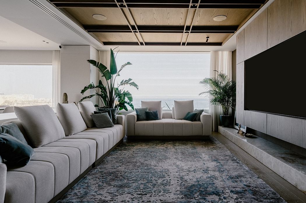 Spacious living room with modern, minimalist furnishings, wood-paneled ceiling, and large windows offering scenic views.