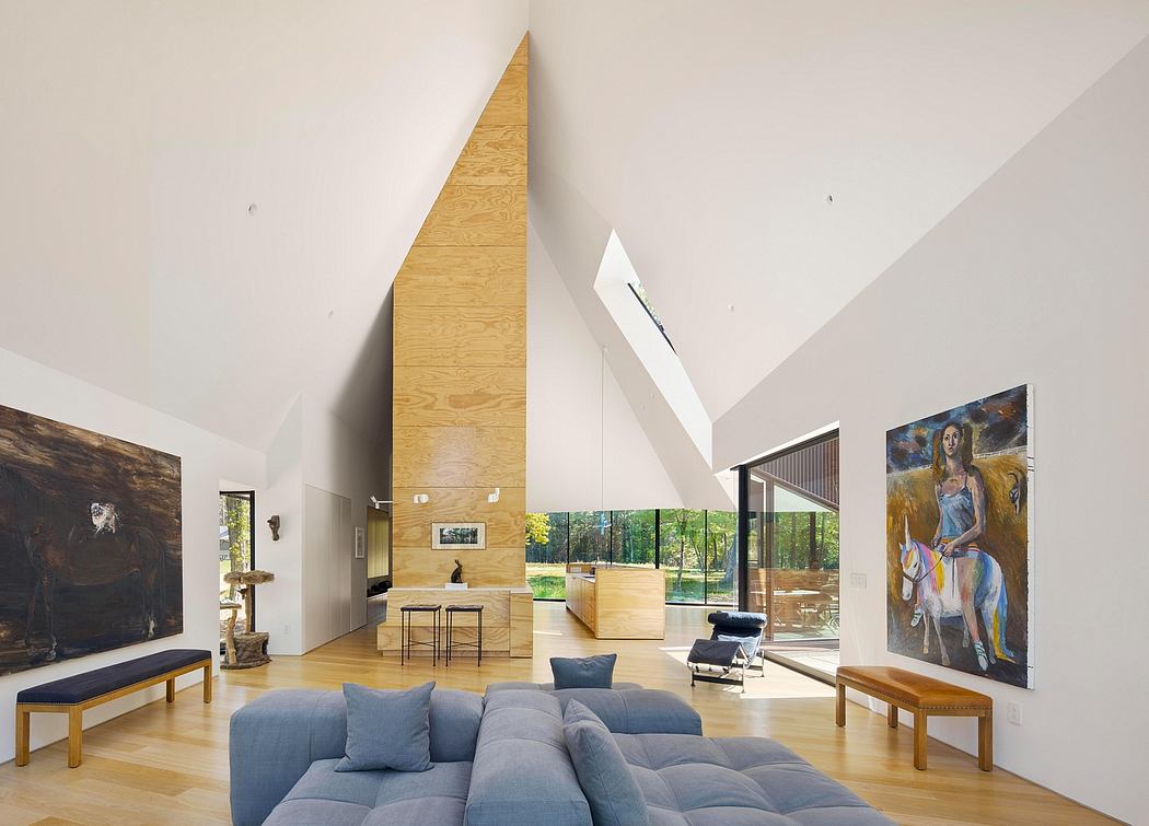 Modern open-plan living space with high ceilings, large windows, and a sculptural fireplace.
