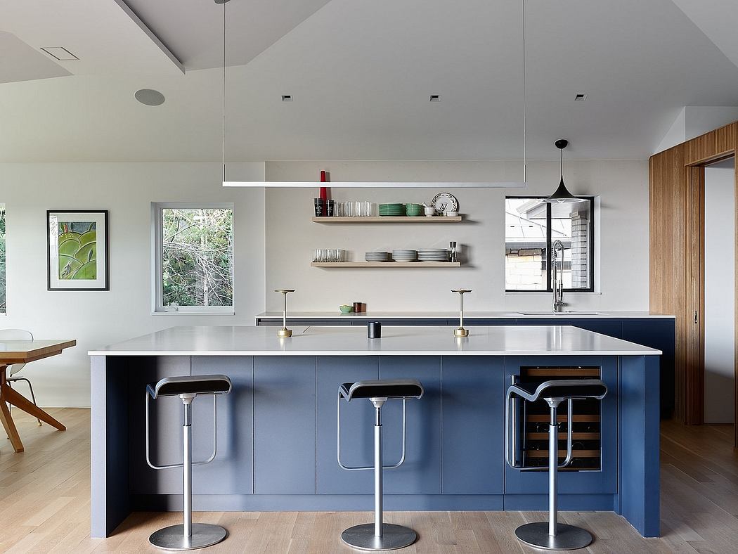 Sleek, modern kitchen with navy blue cabinets, floating shelves, and pendant lighting.