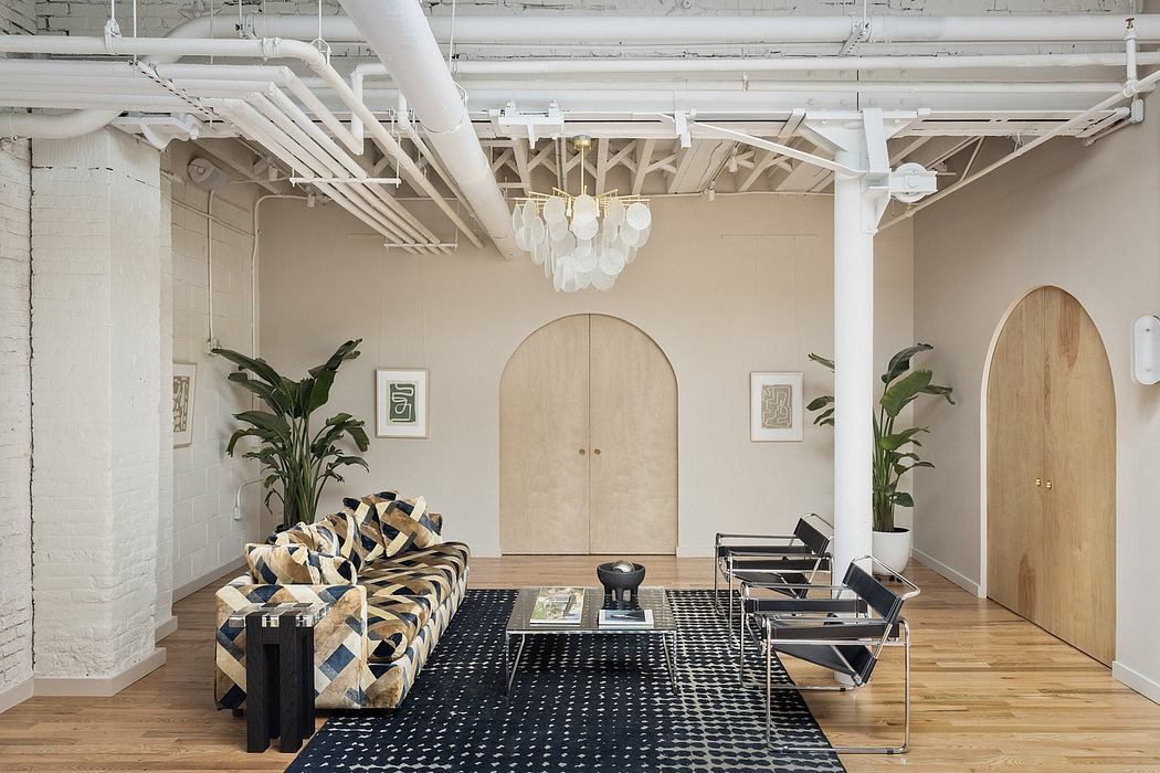 A spacious, loft-inspired living room with exposed brick walls, arched doorways, and a statement chandelier.