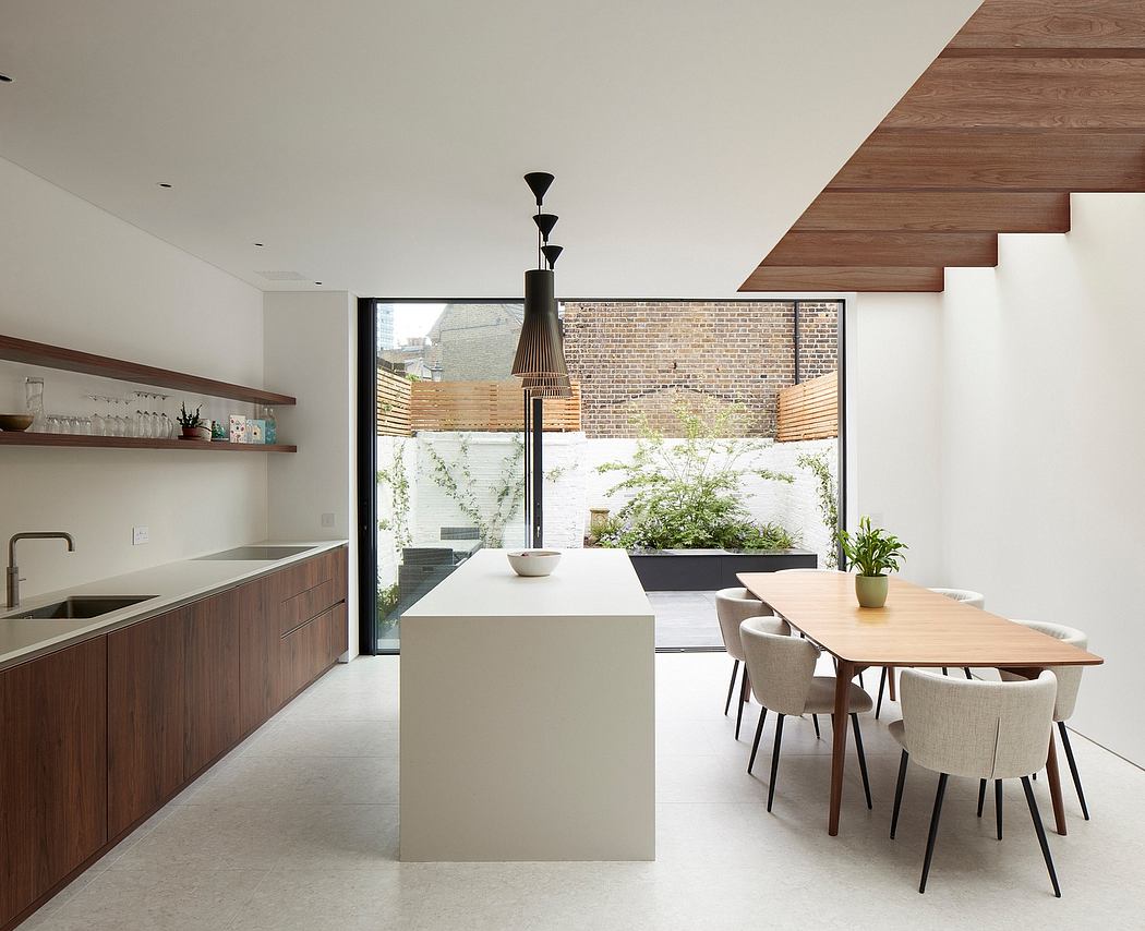 Minimalist kitchen and dining area with exposed brick, wooden accents, and large window.
