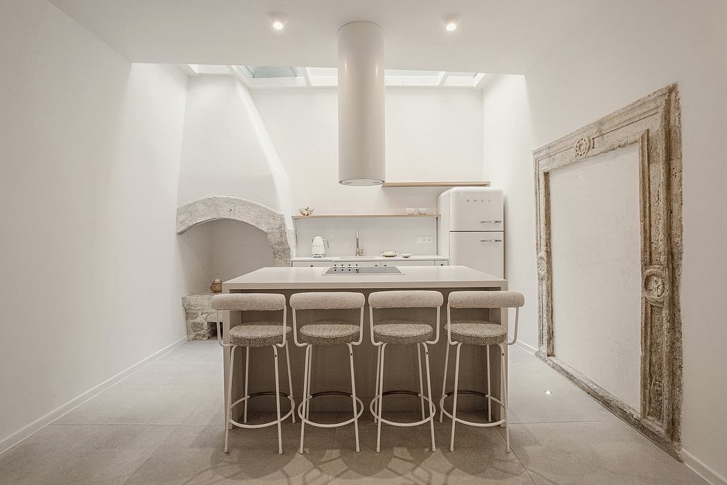 A modern, minimalist kitchen with vintage architectural elements and natural lighting.
