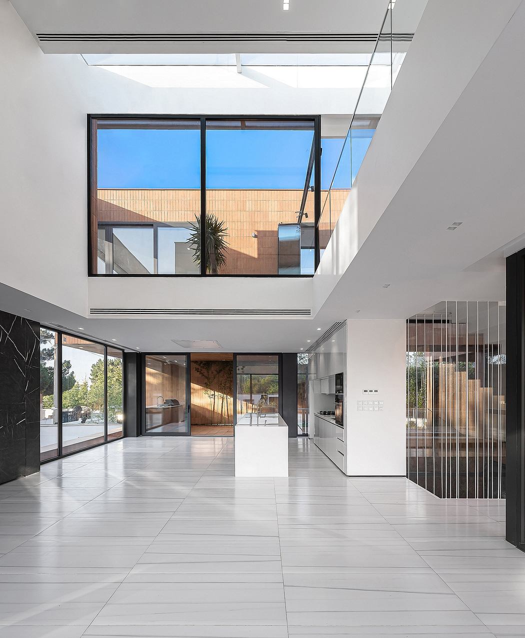 Expansive modern interior with large windows, sleek tiled floors, and minimalist design.