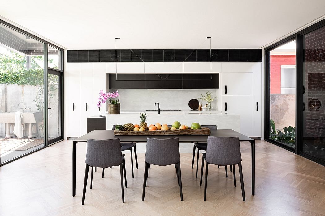 Sleek and modern kitchen with minimalist black and white decor, large windows, and a wooden dining table.