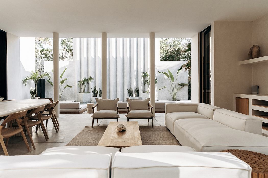 Serene, open-concept living space with modern furniture, large windows, and potted plants.