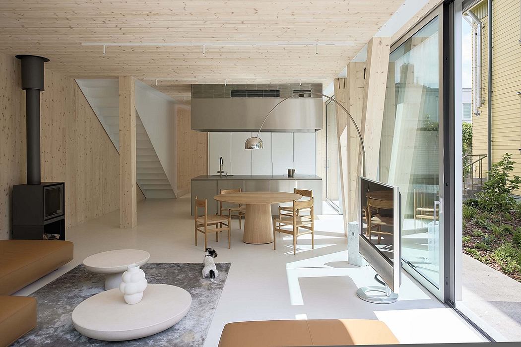 Bright, airy open-plan living space with modern wood and steel accents, large windows.