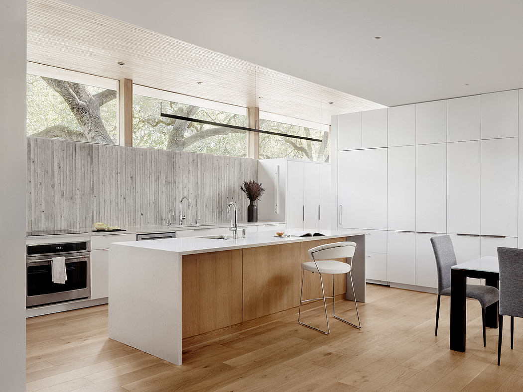Minimalist kitchen with wooden accents, large windows, and modern appliances.
