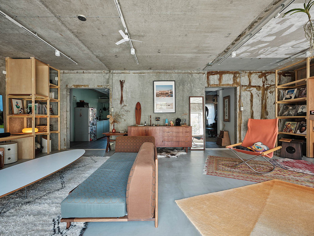 A modern, industrial-style loft with exposed concrete walls, wooden shelving, and vibrant furnishings.