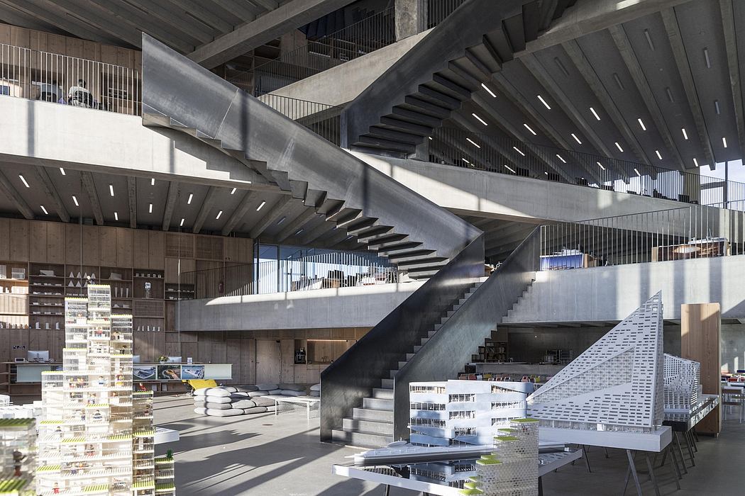 Expansive interior of a modern building with dramatic stairs and exposed concrete.