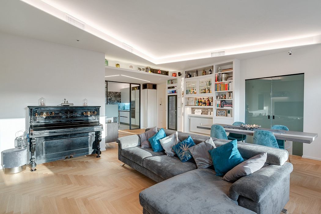 Spacious living room with plush gray sectional, piano, and built-in bookshelves.