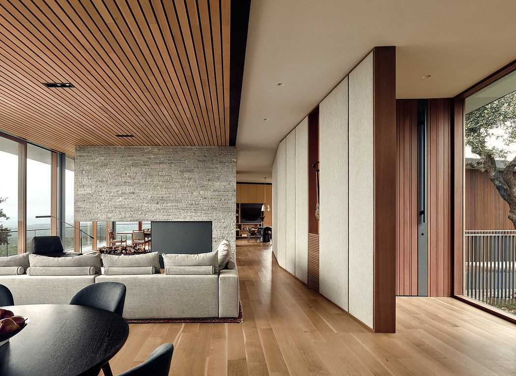 Spacious living room with wood paneled ceiling, stone wall, and open concept design.