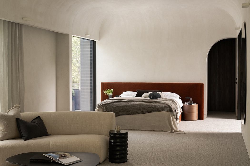 Spacious bedroom with minimalist design, arched ceiling, and neutral color palette.