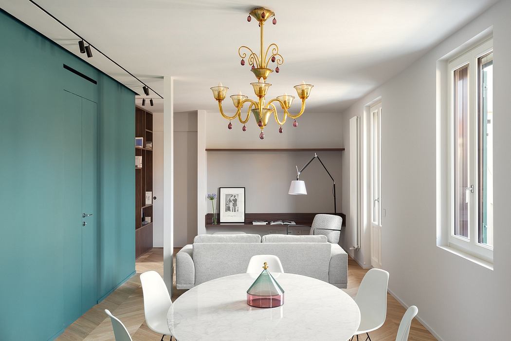 Elegant living room with a modern, colorful chandelier and a cozy seating area.