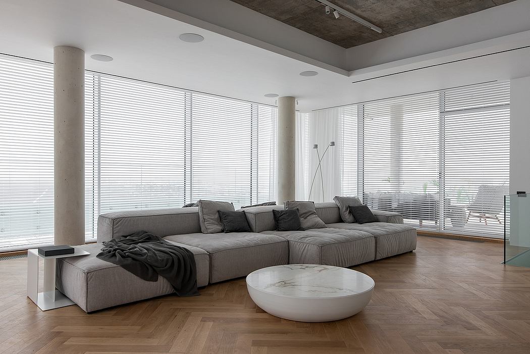 Expansive modern living room with large sectional sofa, marble coffee table, and wood floors.