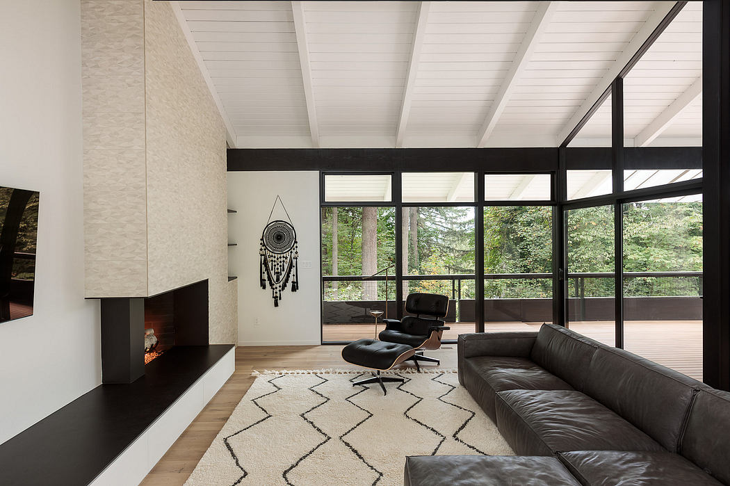 Minimalist living space with large windows, slanted ceiling, and modern furnishings.