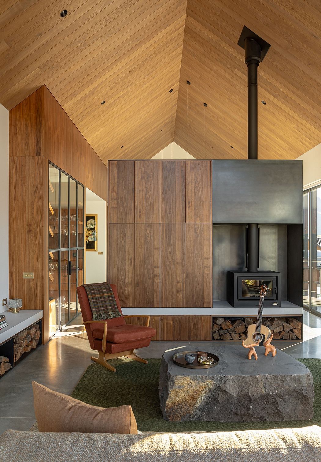 Cozy wooden cabin interior with a stone fireplace, built-in storage, and plush seating.