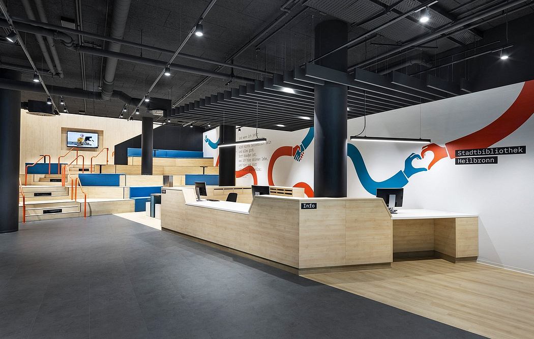 Spacious, modern library interior with bold geometric wall art and wooden service desks.