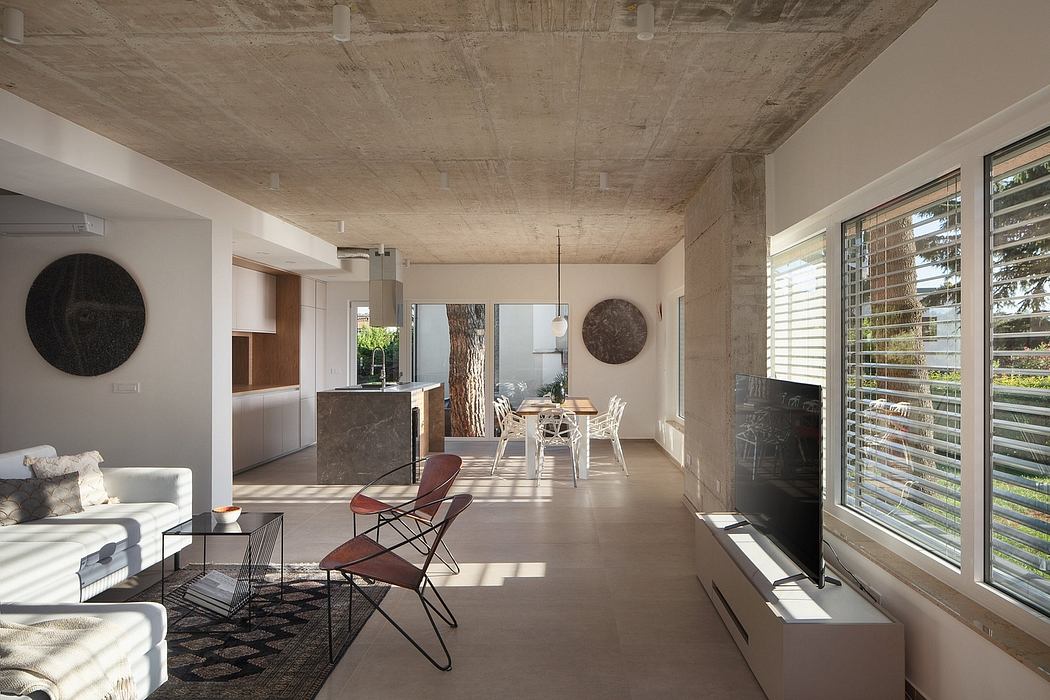Spacious open-concept living area with exposed concrete ceiling and modern furnishings.