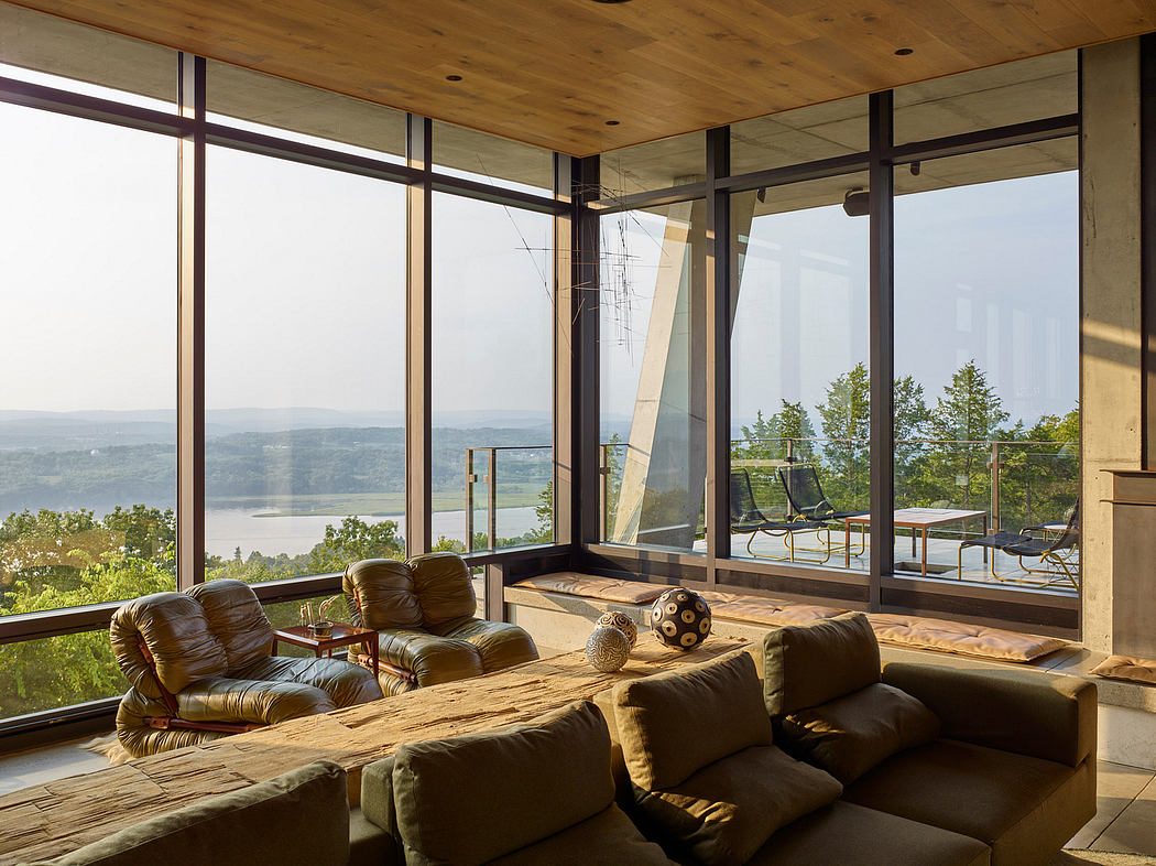 Spacious living room with panoramic windows showcasing scenic landscape views.
